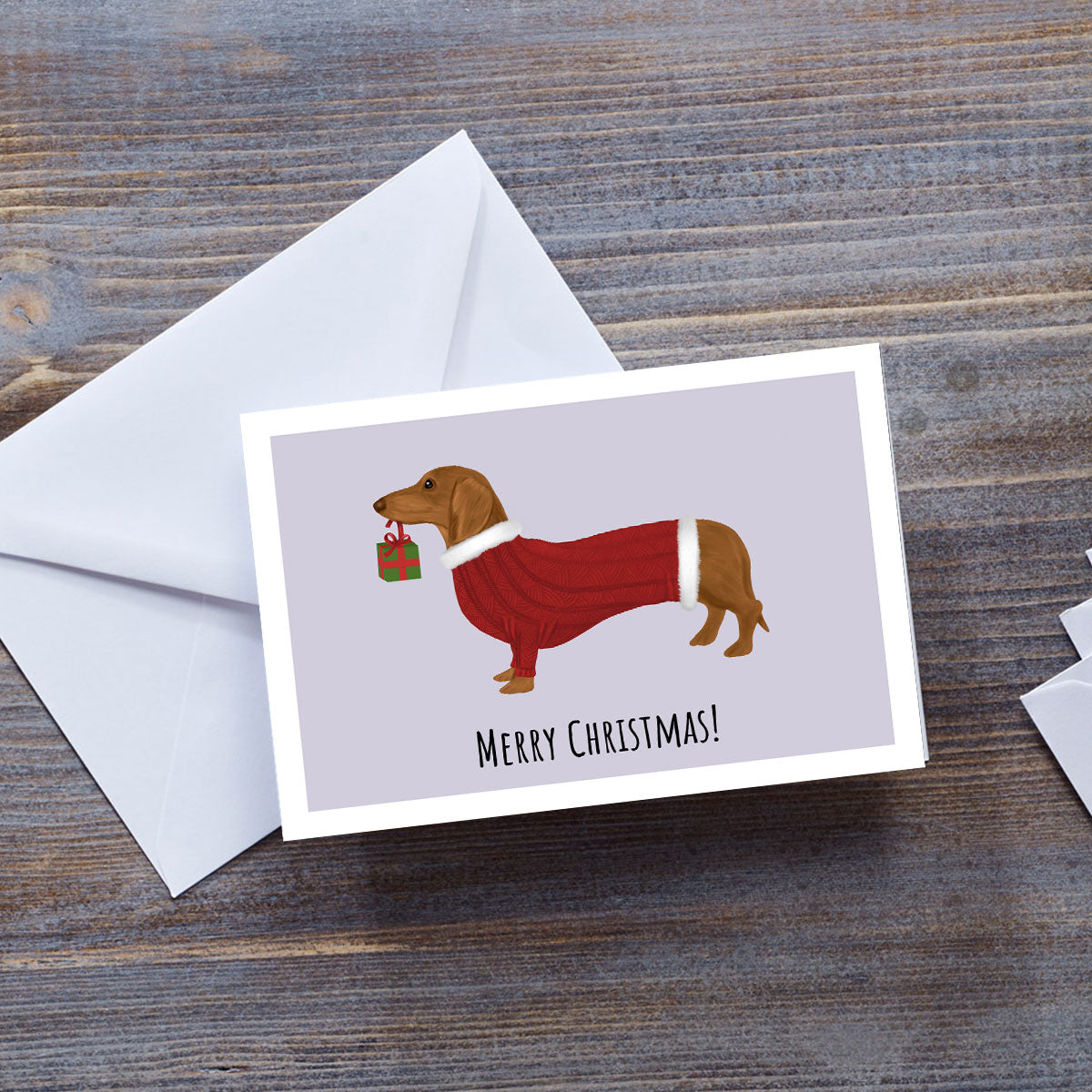 Dachshund Hound in Red Jumper holding gift Christmas card by Oundle Artist Kitty's Art