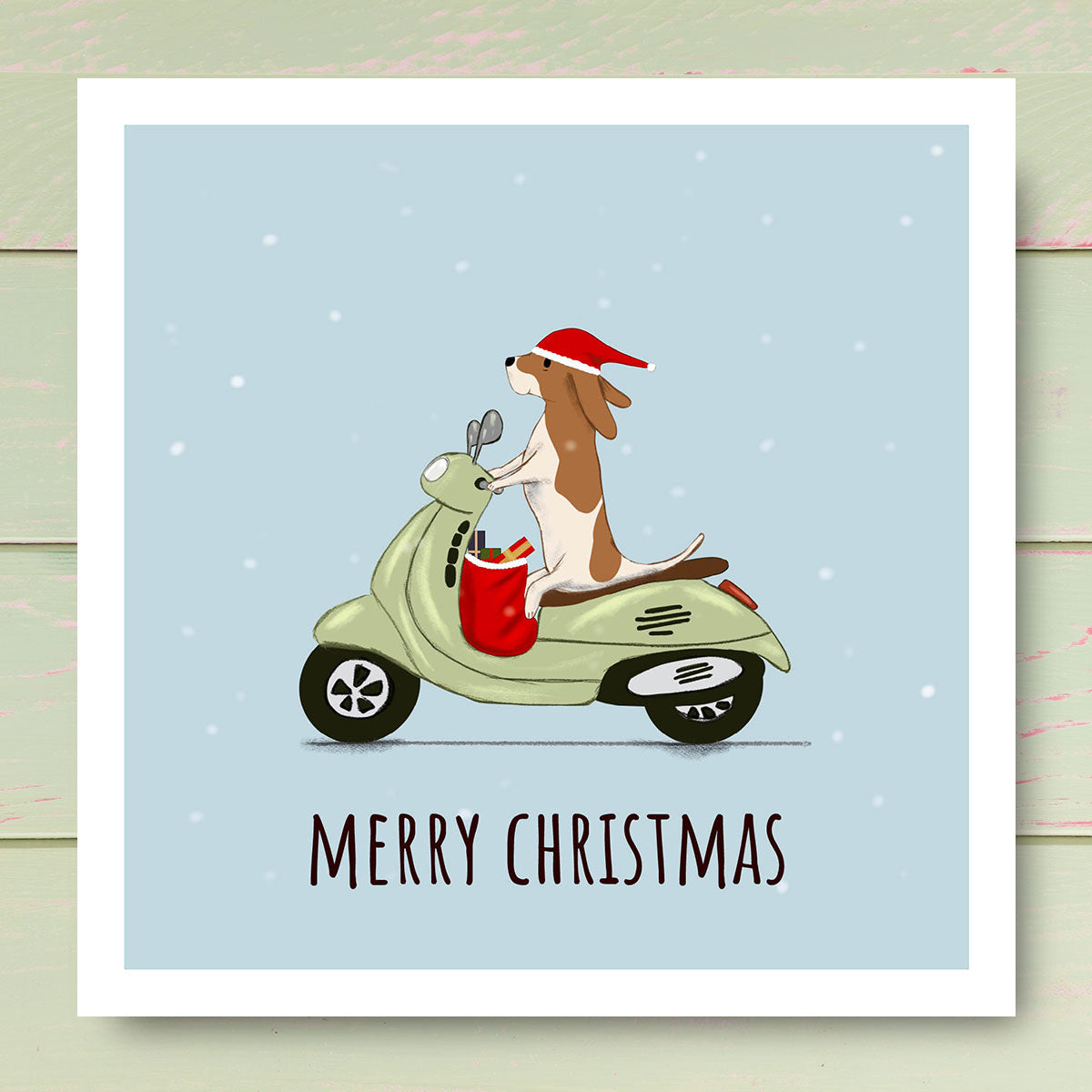 Dog riding a Vespa Scooter wearing Santa hat. Christmas card illustrated by Oundle Artist Kitty's Art